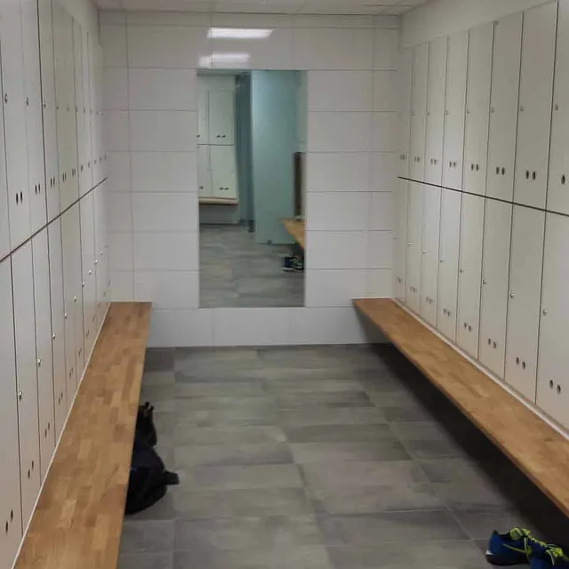 Renovert garderobe med benker på hver side og låsbare skap
